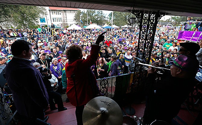 Grammy Award winning recording artist Irma Thomas, known as the "soul Queen of New Orleans," performs on the front porch of a home on Orleans Ave., as crowds wait for the Krewe of Endymion Mardi Gras parade to pass in New Orleans, Saturday, Feb. 6, 2016.