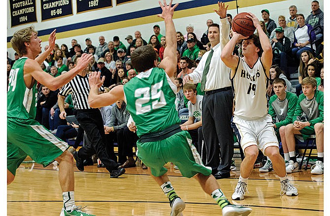 Weston Porter of Helias pulls up and drains a 3-pointer despite the best defensive efforts of Blair Oaks' C.J. Closser (25) and, Kellen Griep (24) on Saturday night at Rackers Fieldhouse.