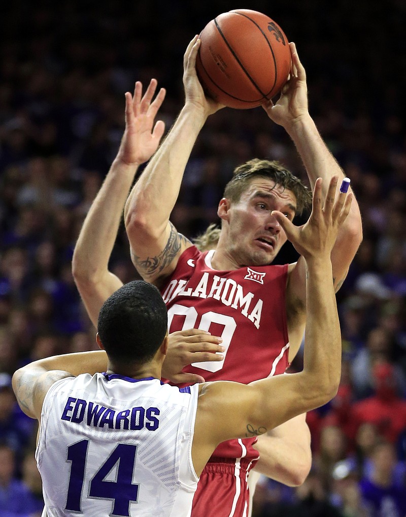 Oklahoma forward Ryan Spangler (00) handles the ball between Kansas State defenders Justin Edwards (14) and Dean Wade, back, during the first half of an NCAA college basketball game in Manhattan, Kan., Saturday, Feb. 6, 2016. 