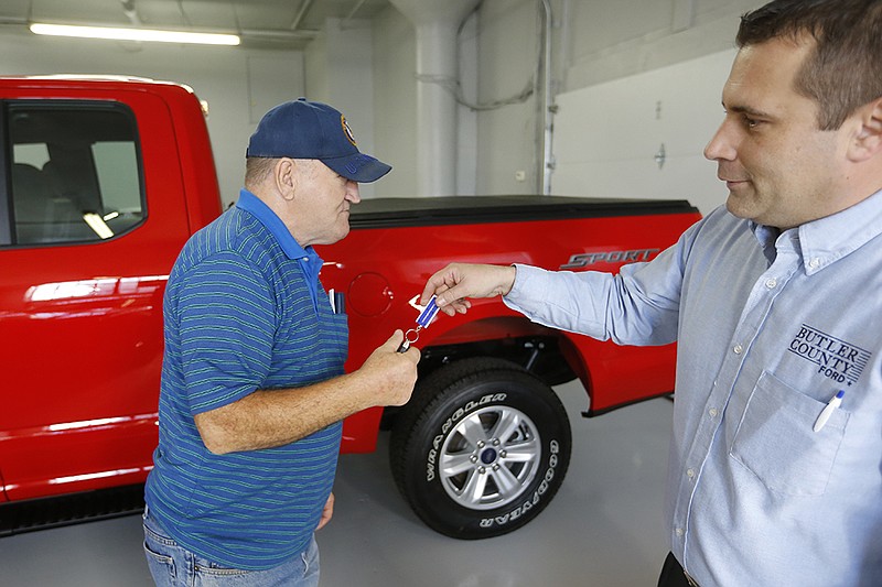 Alton John, left, gets the keys to his new 2015 Ford F-150 Supercab 4x4 pickup from salesman Robert Myers on Nov. 19, 2015, at Butler County Ford in Butler, Pa. Haggling over a car price isn't for everyone. The angst has spawned a small but growing trend toward no-haggle alternatives found at discount club stores, some dealers and several Internet sites. 
