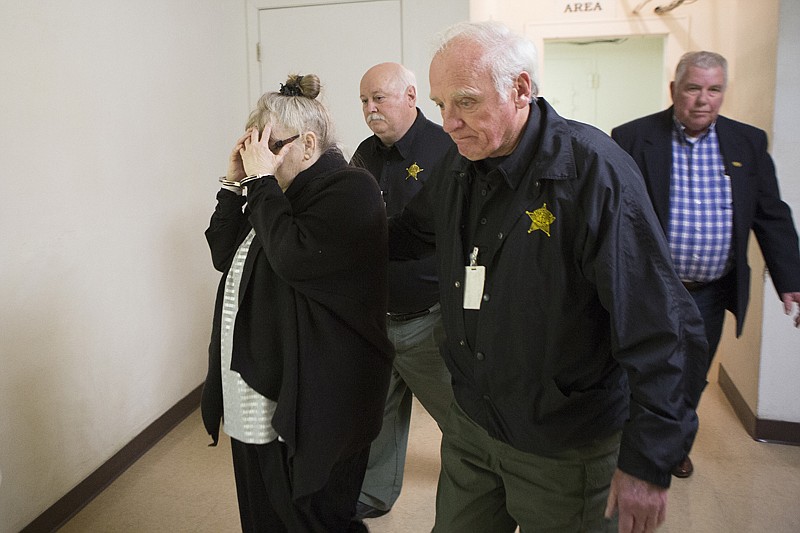 Virginia Hyatt 67, shields her face from the camera Monday evening as she is taken back to jail after being convicted of capital murder in the 2013 fatal shooting of a fellow square dancer. Hyatt blamed Patricia Wheelington for the end of her 40-year marriage.   