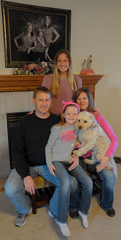 Kenny and Christiane Goans, married 23 years, are pictured with their youngest two daughters, Ashtyn, 17, and Kenzleigh, 9. Their oldest daughter Tylere, 23, is in the portrait above and one-year-old Murphy, a mini-golden doodle is on Christiane's lap.