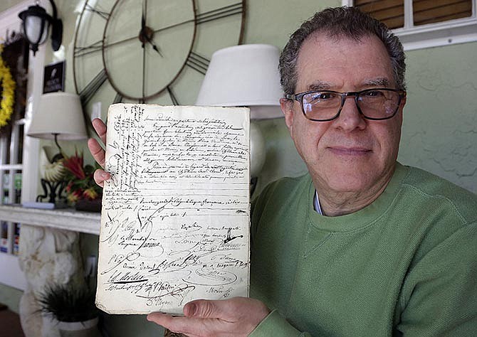 David Lowenherz holds up a marriage contract signed by Napoleon Bonaparte and Josephine de Beauharnais on Monday in West Palm Beach, Florida.