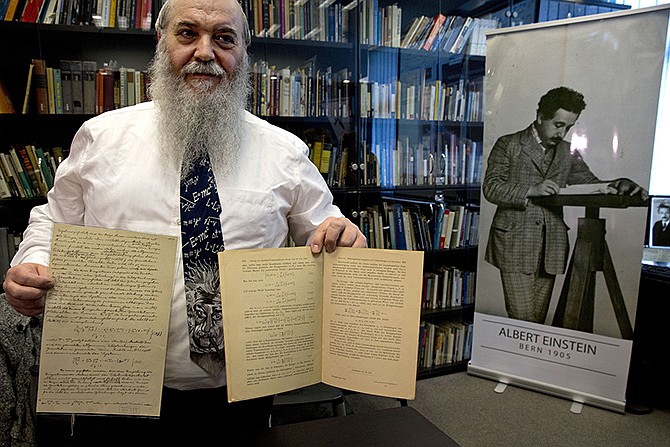 Hebrew University's Roni Gross holds the original historical documents related to Albert Einstein's prediction of the existence of gravitational waves Thursday at the Hebrew university in Jerusalem. In a blockbuster announcement, scientists said after decades of trying, they have detected gravitational waves, the ripples in the fabric of space-time that Einstein predicted a century ago. 