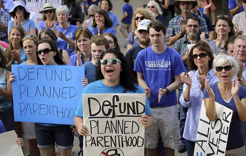 In this July 28, 2015 file photo, Erica Canaut, center, cheers as she and other anti-abortion activists rally on the steps of the Texas Capitol in Austin to condemn the use in medical research of tissue samples obtained from aborted fetuses. Two state health researchers in Texas are under fire for a co-authoring a study suggesting what Republican leaders have long disputed—that cuts to Planned Parenthood are hurting access to women's health care. 