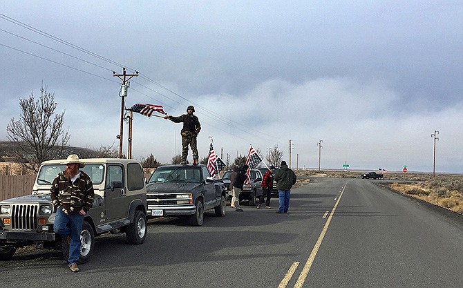 People wave American flags near the Malheur National Wildlife Refuge Thursday near Burns, Oregon. The last four armed occupiers of the national wildlife refuge in eastern Oregon turned themselves in Thursday, after law officers surrounded them in a tense standoff. 