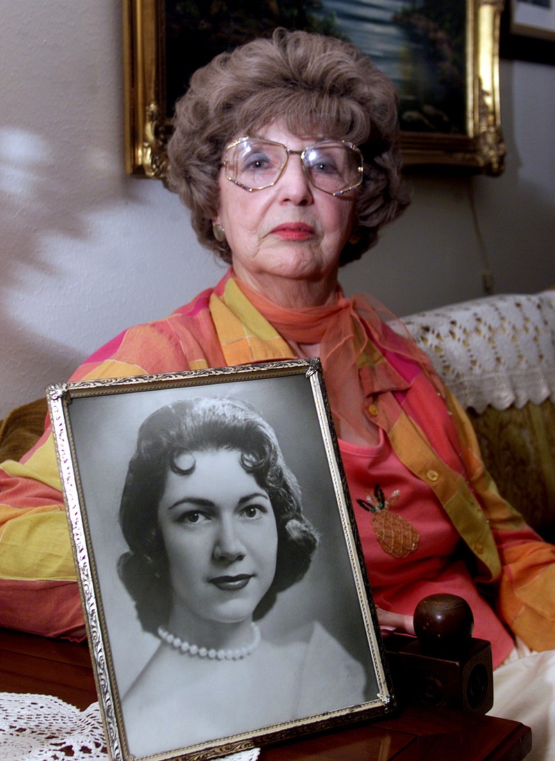 In this April 24, 2003, photo, Herlinda de la Vina holds a portrait of her niece, Irene Garza, the 25-year-old Texas schoolteacher and beauty queen in Edinburg, Texas, who was murdered in McAllen, Texas in 1960. The Maricopa County Sheriff's Department arrested 83-year-old John Feit, former priest, on Tuesday, Feb. 9, 2016, in the slaying of Garza.
