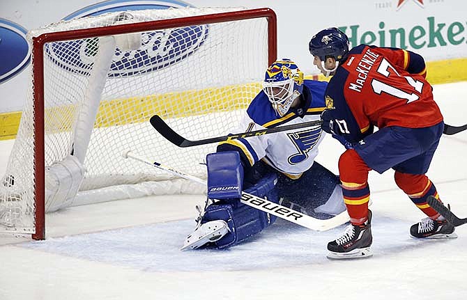 Florida Panthers center Derek MacKenzie (17) scores against St. Louis Blues goalie Brian Elliott (1) during the first period of an NHL hockey game, Friday, Feb. 12, 2016, in Sunrise, Fla.
