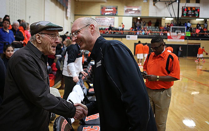 Max Wolfram, left, former Webster Groves superintendent, shakes hands with Jon Clark before the start of the Webster Groves boys basketball on Thursday, Feb. 11, 2016. Clark, who is battling brain cancer, was guest coaching for the night in the effort to get to his 100th win. 