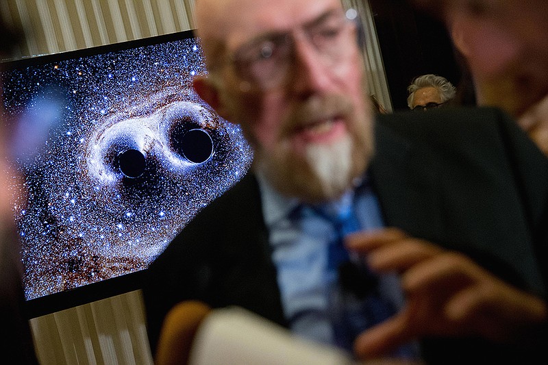 A visual of gravitational waves from two converging black holes is depicted on a monitor behind Laser Interferometer Gravitational-Wave Observatory (LIGO) Co-Founder Kip Thorne as he speaks to members of the media following a news conference at the National Press Club in Washington, Thursday, Feb. 11, 2016, as it is announced that scientists they have finally detected gravitational waves, the ripples in the fabric of space-time that Einstein predicted a century ago. The announcement has electrified the world of astronomy, and some have likened the breakthrough to the moment Galileo took up a telescope to look at the planets. 