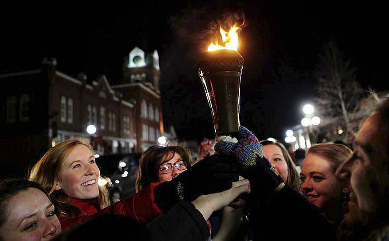 In this Friday, Feb 5, 2016 photo provided by the Newport Recreation Department, queen contestants participate in the torch lighting during the opening ceremony of the 100th Newport Winter Carnival in Newport N.H.  People for the Ethical Treatment of Animals, or PETA, launched a protest against one of the carnival events billed as a "Greased Pig on Ice," but withdrew it after learning there's no pig in the act. The event will feature a man dressed in a pig costume, being chased by kids on ice skates on the town common. 
