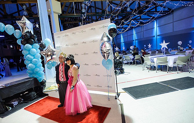 Chance Hendricks, left, and Angel Kleffner stand together for a red carpet photo shortly after arriving at the Night to Shine special needs prom Friday night at Capital West Christian Church in Jefferson City.