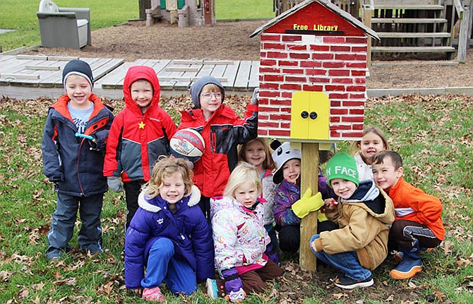 Students of Sherri Griffin's preschool class in Millersburg sit next to the town's new Little Free Library, which opened Jan. 12. The library includes picture books and chapter books for kids.