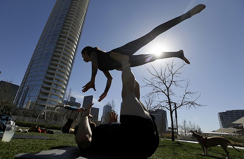 Karla Gallegos is lifted as she practices acro yoga with friends Thursday, Feb. 11, 2016 in downtown Dallas. Springlike weather has moved into Texas making being outdoors during winter enjoyable.
