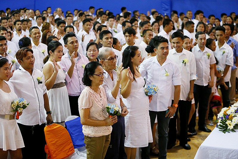 Filipino couples take their oaths Friday during a mass wedding ahead of today's Valentine's Day celebration  in Manila, Philippines. About 350 couples exchanged vows in the wedding sponsored by Manila City Hall.