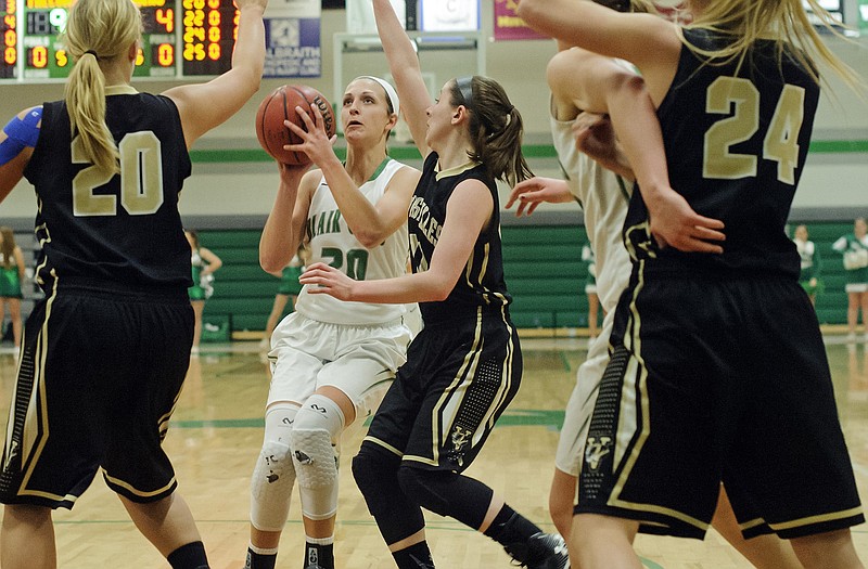 Blair Oaks' Macyn Wilbers pulls up for a jump shot in front of Versailles teammates Nicole Lehman (11) and Maddy Hibdon (20) during Monday night's game in Wardsville.