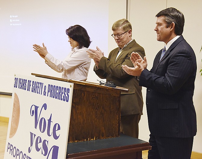 Brad Bates, right, Roger Schwartz and Lori Hoelscher, co-chairs of Citizens for Proposition A, applaud at the conclusion of the presentation of improvements made using the half cent sales tax in Cole County. The campaign hosted a kickoff event at Capital Mall Thursday morning.