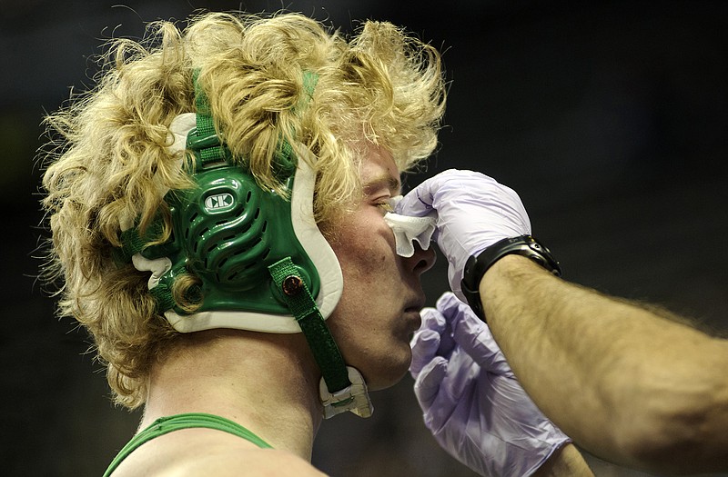 A member of the medical staff tends to the nose of Blair Oaks' Chance Cumpton during Thursday's action at the Class 1 state championships at Mizzou Arena.