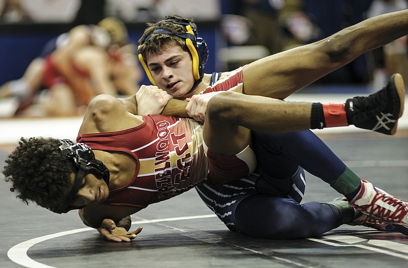 Helias' Evan Winder (top) tries to force Hazelwood East's Fedrick Johnson onto his back in their opening-round match Thursday at 106 pounds in the Class 3 championships at Mizzou Arena.