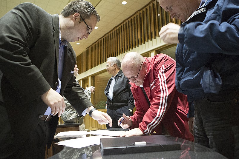 Attorney Travis Story goes over a petition Tuesday night, Feb. 23, 2016 with former Texarkana, Ark., Mayor Wayne Smith and others challenging the city of Texarkana, Ark., anti-discrimination policy at a meeting held at the Omega Building in downtown Texarkana. 