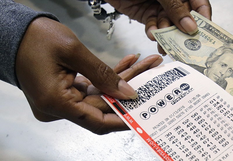 In this Jan. 13, 2016 file photo, a clerk hands over a Powerball ticket for cash at Tower City Lottery Stop in Cleveland. The Associated Press has learned that the group that runs Powerball approved, then backed off, changes that would have given ticket buyers more bang for their two bucks than the game redesign implemented last year. In October, Powerball managers changed the game's matrix in a bid to build bigger jackpots to revive lagging player interest and ticket sales.