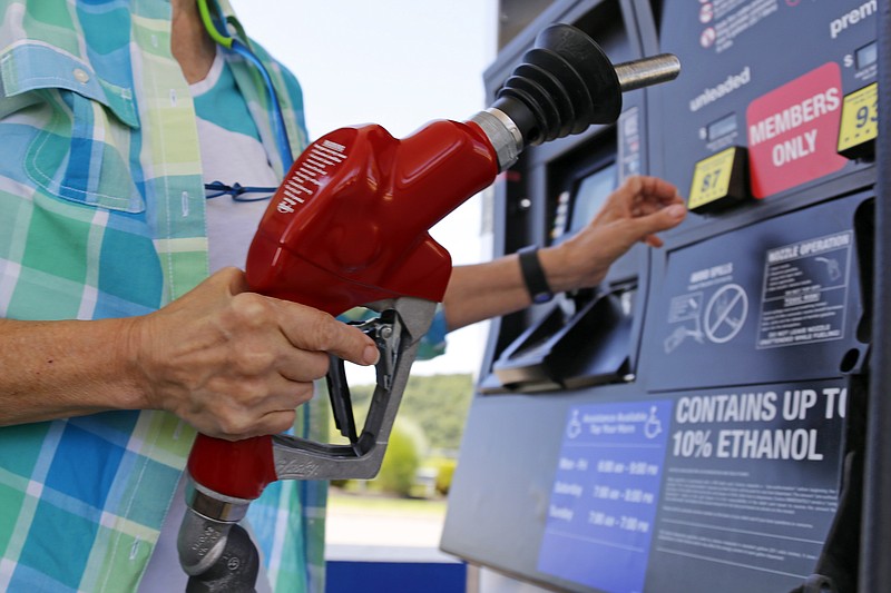 In this Thursday, July 16, 2015, file photo, a customer refuels her car at a Costco in Robinson Township, Pa. 