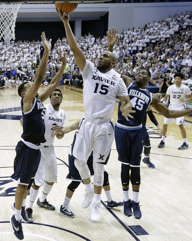 Xavier's Myles Davis (15) shoots against Villanova's Phil Booth, left, and Darryl Reynolds (45) during the second half of an NCAA college basketball game, Wednesday, Feb. 24, 2016, in Cincinnati. Xavier won 90-83. 