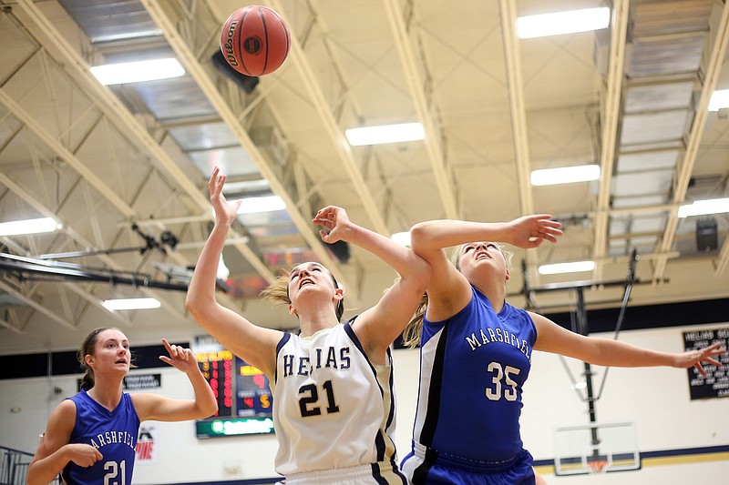 Mai Nienhueser of Helias watches her shot while Marshfield teammates Jay Katie French (35) and and Peyton Greenlee (21) defend during Thursday's game at Rackers Fieldhouse.