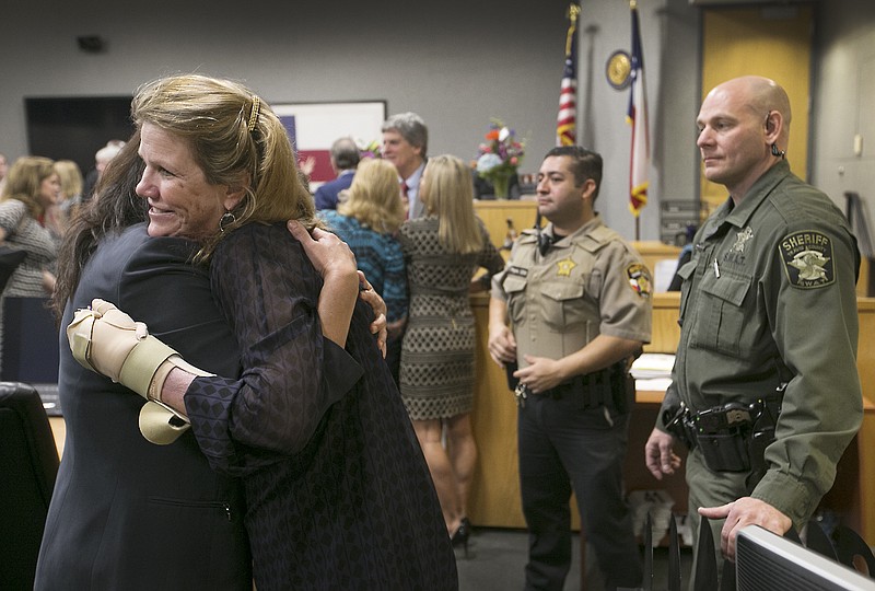 Travis County District Judge Julie Kocurek, right, hugs close friend defense attorney Sylvia Acosta after returning to court, Monday, Feb. 29, 2016 in Austin.  Kocurek returned after recovering from the Nov. 6 attack at her home.  Police say they think a defendant in her court, Chimene Onyeri of Houston, opened fire on Kocurek weeks before a hearing in which prosecutors were seeking to revoke his probation on a larceny charge that would have sent him to prison. 