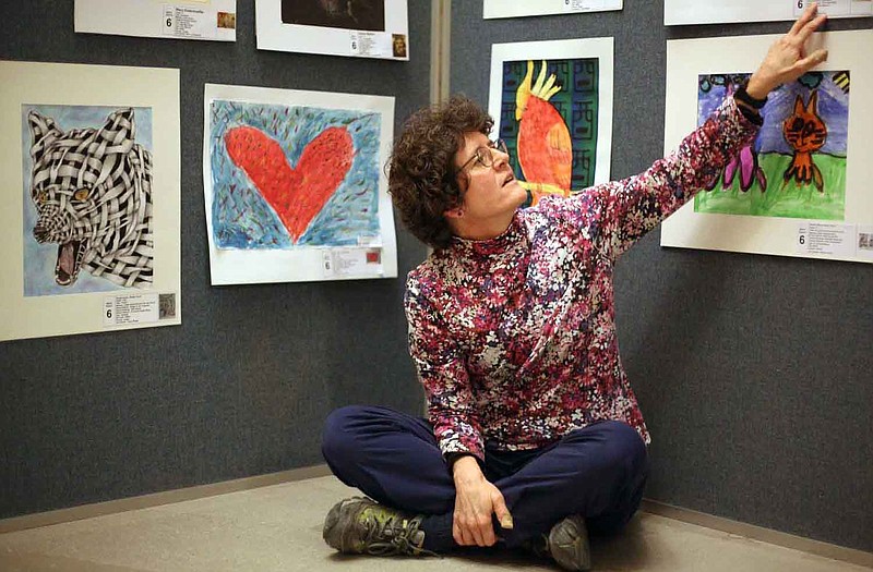 
Art teacher Amy Potts poses for a portrait next to the heart painting, one of her favorite pieces of artwork created by her students in the Russellville school district in the Capitol building.