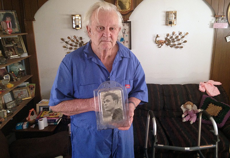 In this undated photo, Donald Burke, of Pollock, La., holds an old photograph of his brother-in-law, Charles Lee Johnson, who died in May 2013 following an altercation with a nursing assistant at a Department of Veterans Affairs medical center in nearby Pineville. Johnson, an Air Force veteran, was 70 years old when he died. VA officials concluded that Johnson died in an accidental fall, but local prosecutors filed a manslaughter charge against the nursing assistant, Fredrick Kevin Harris. His trial, currently set for March 7, 2016, is expected to be postponed. 