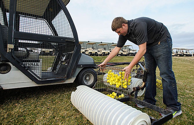 Oak Hills Golf Center assistant clubhouse manager Bryn Boeckman consolidates cages of practice balls after collecting them during a sweep of the driving range on March 7, 2016.