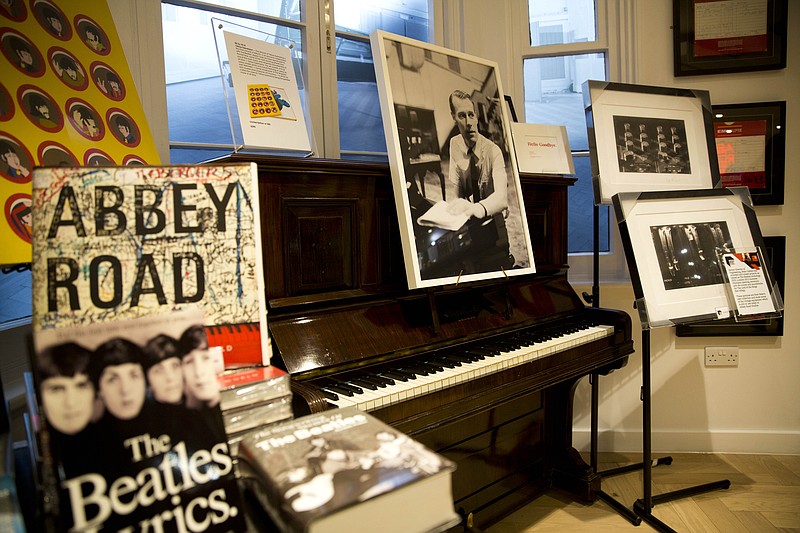 An image of George Martin, the Beatles' producer, is displayed Wednesday, March 9, 2016, in memory of him in the Abbey Road shop by the studios where the Beatles recorded albums and where the zebra crossing cover picture of the Abbey Road album was originally taken in London. George Martin, the Beatles' urbane producer who quietly guided the band's swift, historic transformation from rowdy club act to musical and cultural revolutionaries, has died, his management said Wednesday. He was 90.