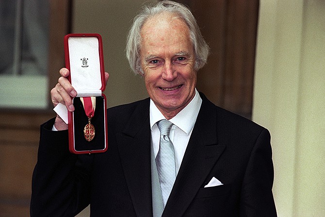 Sir George Martin poses for the media in 1996 with his knighthood at Buckingham Palace, London. George Martin, the Beatles' urbane producer who quietly guided the band's swift, historic transformation from rowdy club act to musical and cultural revolutionaries, has died, his management said Wednesday. He was 90. 