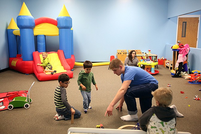 Connor Quin, 16, plays with brothers Carlos, 6, at left, and Harold, 2, in one of the new playrooms Tuesday at Woodcrest Chapel.