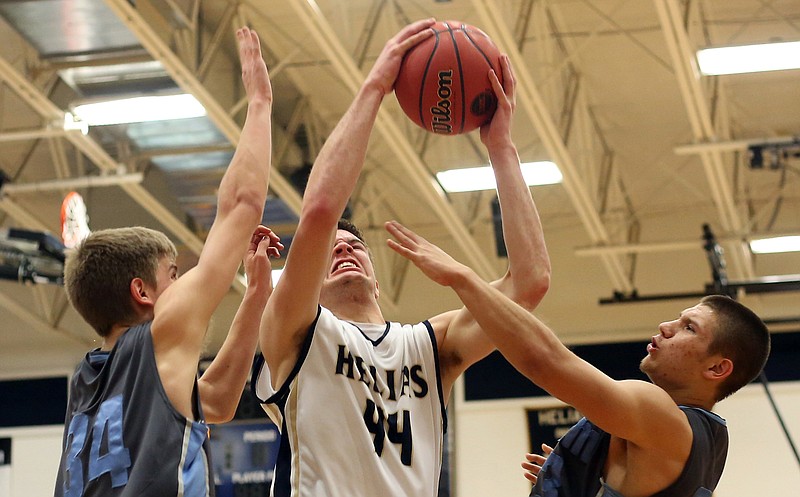 Trevor Koelling of Helias works between a pair of Salem defenders during district tournament action earlier this month at Rackers Fieldhouse.