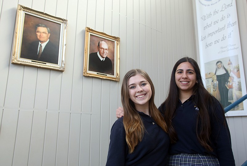 Lauren Micke, 16, left, and Nadine Brahim, 17, pose Thursday at Helias Catholic High School. Micke will be traveling to Spain to study abroad, and Brahim is from Cucuta, Colombia, but has been studying at Helias since August.