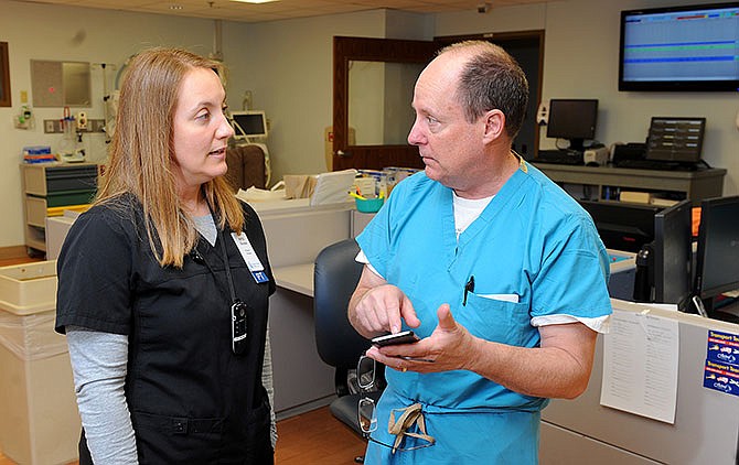 In a March 10, 2016 photo, Tim O'Connor, director of neonatal otology at Boone Hospital Center in Columbia, Mo., talks with physical therapist Katie Goodlet about instructions for working with premature babies. Feeding a baby with donor milk provided by the OhioHealth Mothers' Milk Bank from the onset has made a significant difference for premature babies at Boone, said Tim O'Connor. (Don Shrubshell/Columbia Daily Tribune via AP)