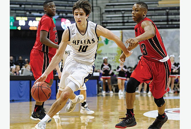 
Helias guard Sam Husting breaks into the lane from the top of the key after beating the double team of Sikeston's Kevin Jones (23) and Fred Thatch (33) off the dribble