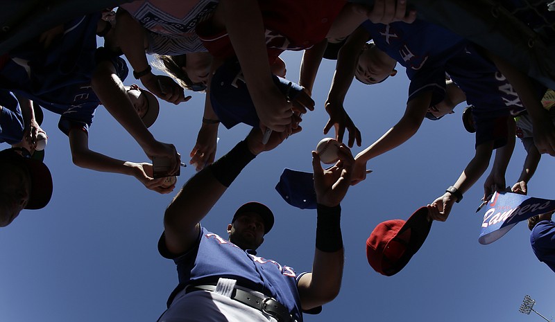 Texas Rangers' Joey Gallo gives autographs before a spring training baseball game against the Oakland Athletics on Saturday, March 12, 2016, in Surprise, Ariz. 