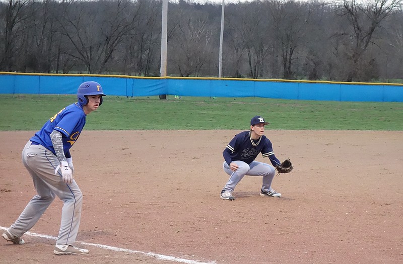 Fatima baserunner Steven Brandt and Helias third baseman Josiah Imhoff watch a pitch to the plate during the bottom of the fifth inning of Tuesday's game in Westphalia.