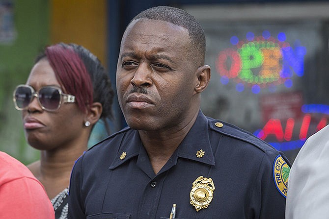 In this Jan. 2, 2016, photo, Miami Police Maj. Delrish Moss stands among the Miami-Dade officials who announced the arrest of Willie "Pee Wee" Wilcher in Liberty City, Fla. Moss was announced as police chief in Ferguson, Mo., Thursday, March 31, 2016, putting a black man in charge of a mostly white department that serves a town where African-Americans make up two-thirds of the residents. (Matias J. Ocner/The Miami Herald via AP)