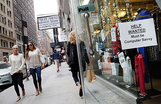 In this Thursday, Oct. 1, 2015, file photo, a "Help Wanted" sign hangs in a store window in New York.