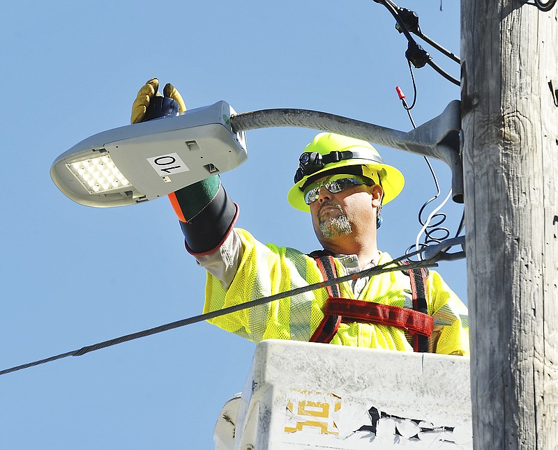 After switching out the old sodium light for the new LED, Mike Griffin, a line service worker for Ameren, makes sure it works properly.