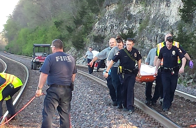 Jefferson City police, fire and EMT personnel carry two injured hikers from the place where they fell from a bluff to a point they could be lowered to the Missouri River for transport to a waiting medivac helicopter.
