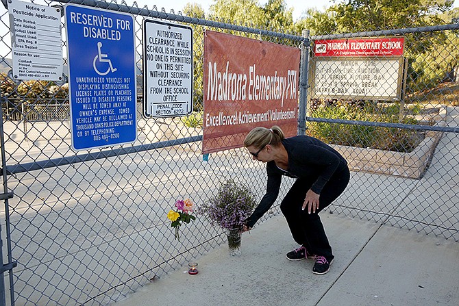 Terri Gaspar places flowers Tuesday at Madrona Elementary School, where a homemade model rocket exploded, killing at least one student, in Thousand Oaks, California.