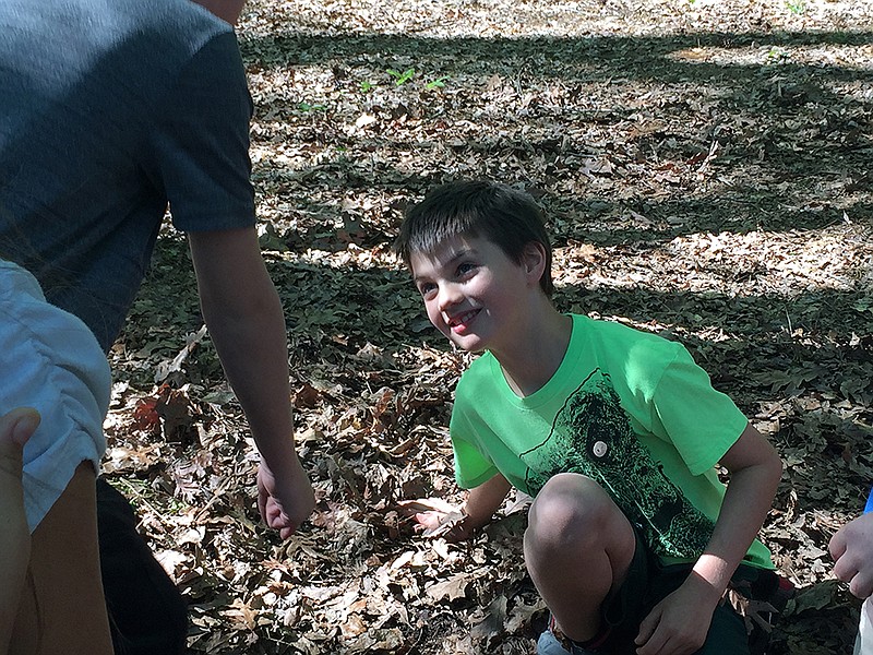 Third-grade students from L.F. Henderson Intermediate School in Ashdown, Ark.,  search a pile of leaves Tuesday, Apr. 5, 2016 during a Learning for Life activity held at Camp Preston Hunt. 