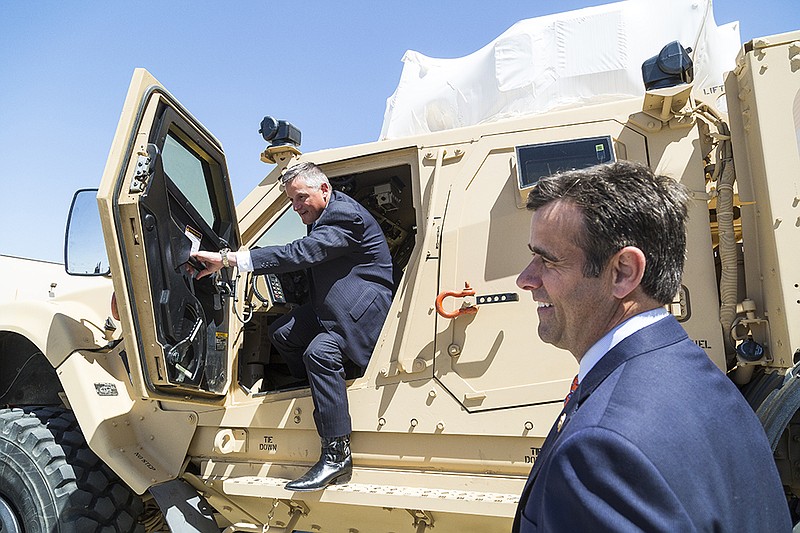 U.S. Rep. Bruce Westerman, R-Ark., climbs out of an Oshkosh MRAP M-ATV and lets U.S. Rep. John Ratcliffe, R-Texas, see the interior Wednesday, Apr. 6, 2016 at Red River Army Depot. This vehicle is one of the many kinds that are partially assembled and upgraded with armor at the Maneuver Systems Sustainment Center at the depot. 