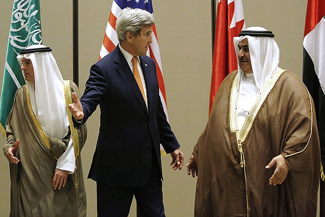 Secretary of State John Kerry talks with Bahrain Foreign Minister Khalid bin Ahmed Al Khalifa, right, Thursday after they and Saudi Arabia Foreign Minister Adel al-Jubeir, left, gathered for a family photo at the start of the Gulf Cooperation Council Ministerial meetings in Manama, Bahrain.