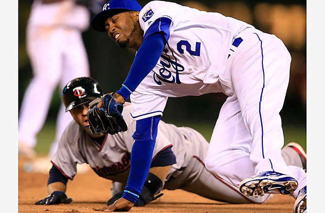 Kansas City Royals shortstop Alcides Escobar (2) falls over Minnesota Twins' Brian Dozier during a rundown between second and third bases in the ninth inning of a baseball game at Kauffman Stadium in Kansas City, Mo., Friday, April 8, 2016. Dozier was out on the play. The Royals defeated the Twins 4-3. 